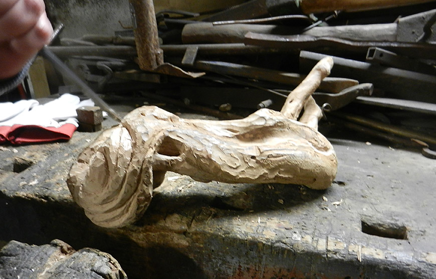 Beeldhouwen in hout. Een vrouw met veel haar hakken uit een entknol van een appelboom.